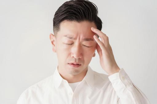 頭をおさえる男性